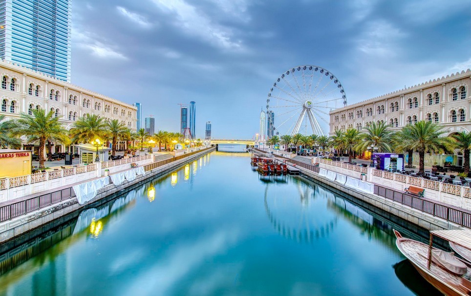 The next emirate that lies between Sharjah and Umm Al Quwain. Name it.